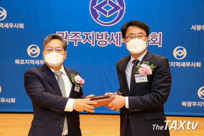 유권규 신임 회장이 정성균 세무사로부터 의상봉을 전달받고 있다.(사진: 광주지방세무사회)