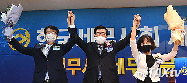 원경희 회장과 연대부회장인 고은경, 임채수 부회장이 꽃다발을 받고 환호하고 있다(사진: 한국세무사회)