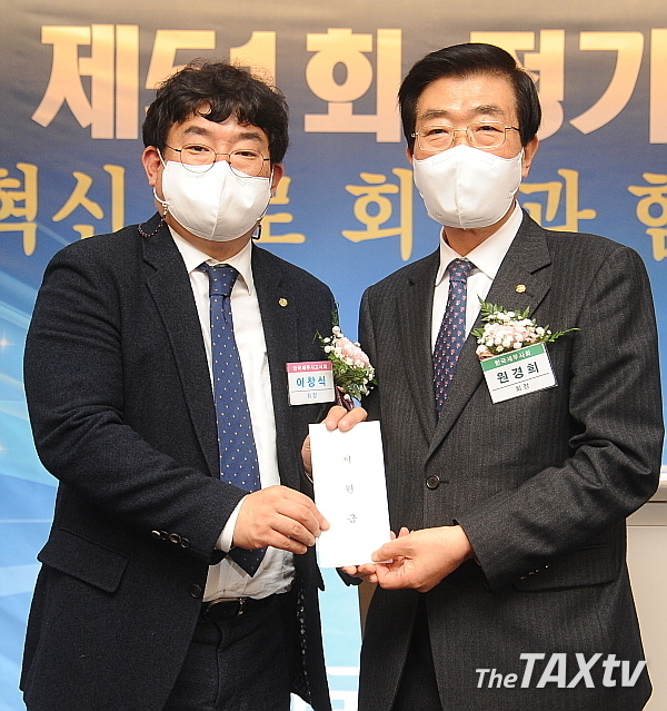 한국세무사회 원경희 회장이 이창식 한국세무사고시회 회장에게 금일봉을 전달하고 있다. (사진: 김용진 기자)