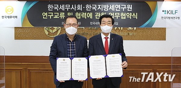 한국세무사회 원경희 회장(사진 오른쪽)과 한국지방세연구원 배진환 원장은 지난 22일 오후 한국세무사회관 3층 소회의실에서 상호 업무협약체결 후 기념촬영을 하고 있다.(사진: 한국세무사회)
