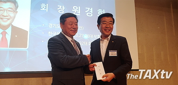 원경희 한국세무사회 회장이 김명진 회장에게 찬조금을 전달하고 있다.(사진: Thetaxtv)