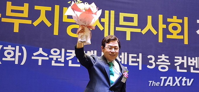 20일 오후 수원컨벤션센터 3층에서 개최된 중부지방세무사회 제42회 정기총회에서 이중건 부회장이 제23대 회장에 단독 출마해 무투표당선된 위 꽃다발을 들고 환호하고 있다.. (사진: 채흥기 기자)