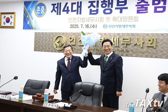 구재이 한국세무사회장이 최병곤 인천지방세무사회장에게 축하 꽃다발을 주고 있다. 사진 오른쪽은 김선명 한국세무사회 부회장. (사진: 인천지방세무사회)